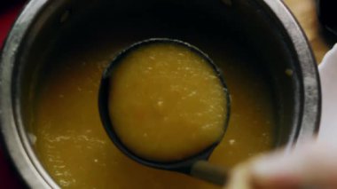 Sebze püresi çorbasının en üst görüntüsü bir kase içinde kepçeleniyor..