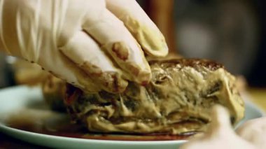 Kişi kızarmış eti hardalla kaplar..