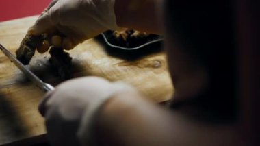 Haşlanmış et, tahta bir kesme tahtasıyla küçük parçalara bölünüyor..