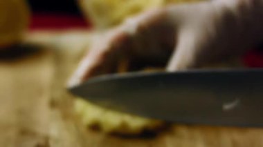 Ananas dilimini küçük küplere doğrayan biri..