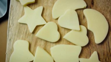 Çeşitli şekillerde kesilmiş peynir dilimlerinin üst görünümü.