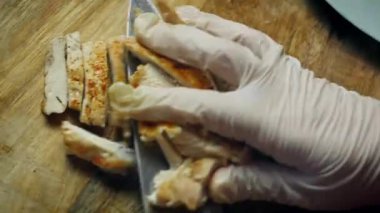 Izgara tavuk göğsü dilimleri bir tabağa aktarılıyor..