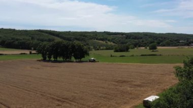 Buğday tarlasında hasatçının geniş açılı görüntüsü. Ayarlama veya efekt olmadan video.