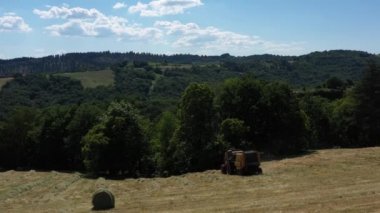 Traktör yuvarlak topçuları becererek uzaklaşıyor. Ayarlama veya efekt olmadan video.