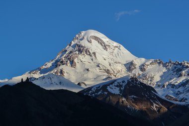 Mount Kazbek karlı zirvesine şafakta. Gürcistan