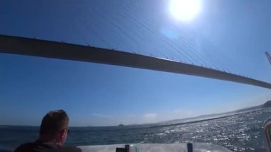 Gergin bir köprünün altında bir teknede