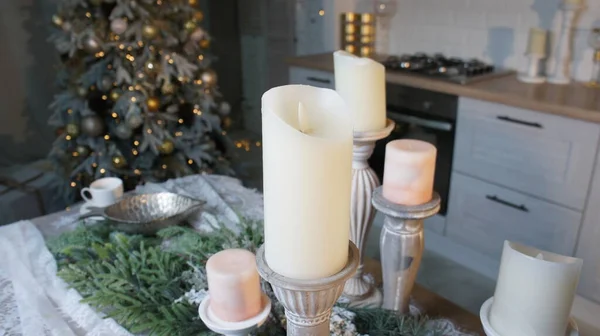 Yeni yıl masası, masa örtüsü, mumlar, kozalaklı dallar.