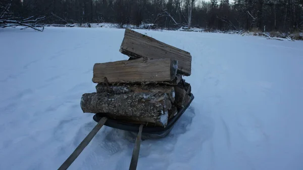 Dřevo na topení ve sněhu, nosíme dřevo na oheň — Stock fotografie