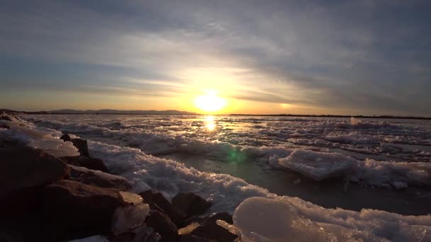 Hermosa puesta de sol rojo-amarillo sobre el río helado, deriva de hielo — Vídeo de stock