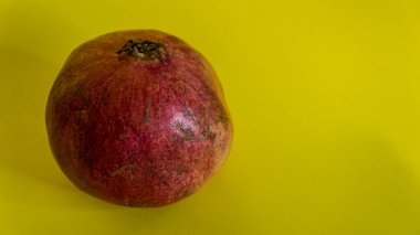 Sarı zemin üzerinde kırmızı nar, sarı zemin üzerinde meyve.