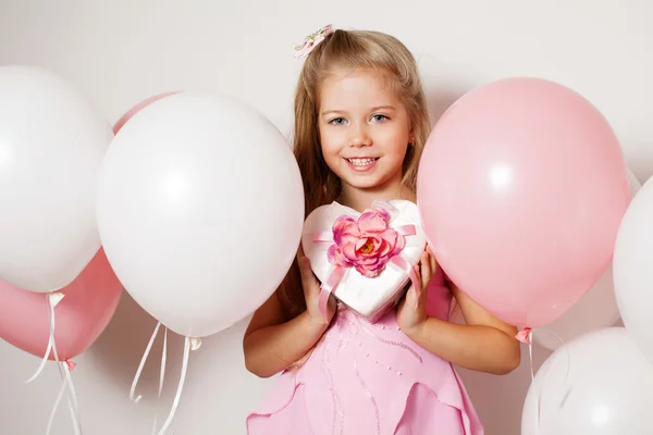 Kalp ve beyaz ve pembe balon şeklinde bir hediye kutusu ile mutlu kız