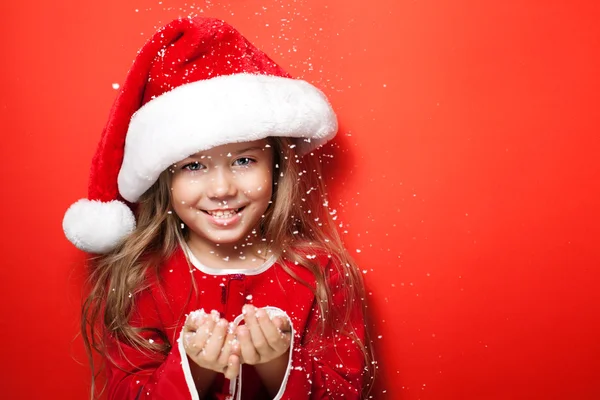 Kar altında Noel şapkalı mutlu kız