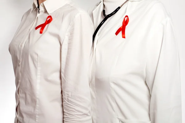 Doktor ve hasta ile kırmızı AIDS bilinçlenme kurdeleleri göğüslerine üzerinde