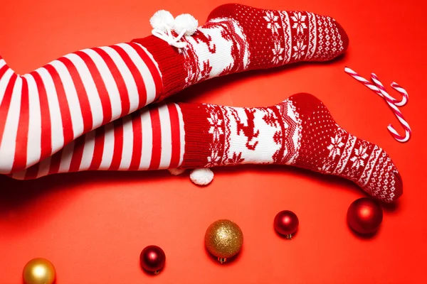 Pernas de Santa mulher em meias quentes com bastões de açúcar e bolas de Natal — Fotografia de Stock