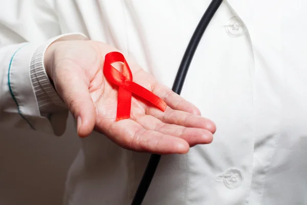 Kırmızı AIDS bilinçlendirme şerit elinde tutan doktor