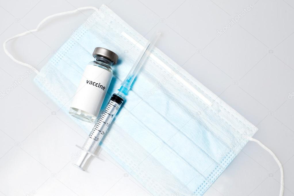 Vaccine capsule with syringe and medical mask. Vaccination. Influenza