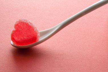 Jöle kalp üzerinde pembe bir arka plan kaşık