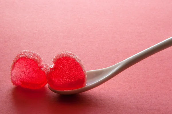 Couple of jelly hearts on the spoon on pink background