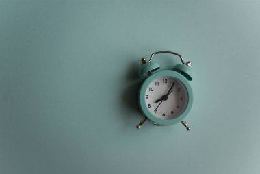 Siyah oklarla birlikte geçmişe dönük alarm saati mavi bir arkaplanda yatıyor