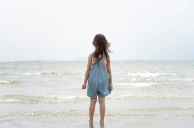 Çocuk Asyalı kızın yaz tatilinde plajda rahatlayıp eğlenmesi..