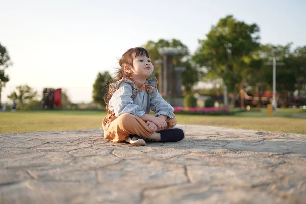 美しい小さなアジアの女の子は屋外の庭に座っています 週末に幸せに座って子供の概念 — ストック写真