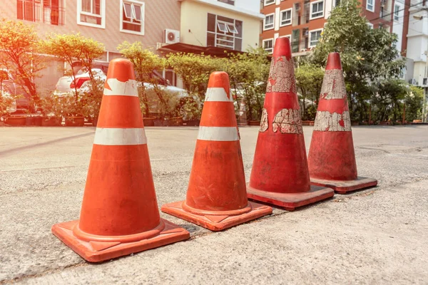 Four old traffic cones on the road surface