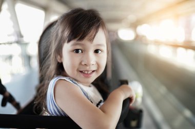 Güzel küçük kız mutlu bir şekilde gülümsüyor. Asyalı çocukların parlak gülümsemeleri