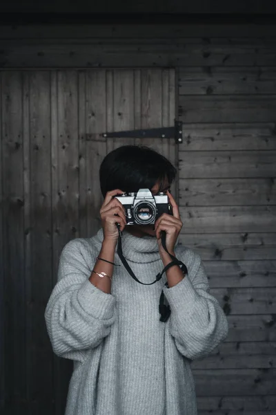 摄影师在木墙前拿着胶卷相机 — 图库照片