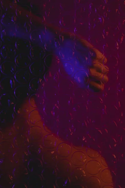 Balonlu naylonun arkasında elini kaldıran bir kadının arkası