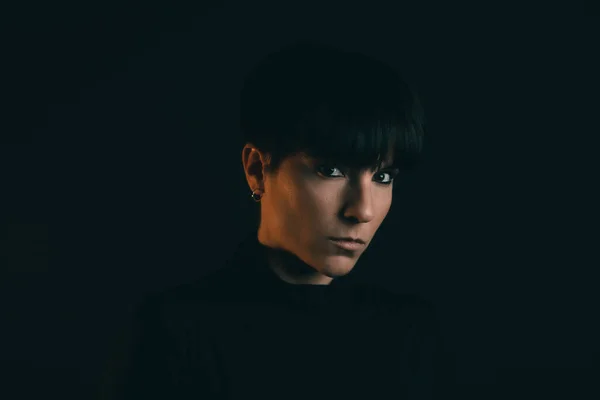 Portrait of an attractive and serious woman looking at camera in studio