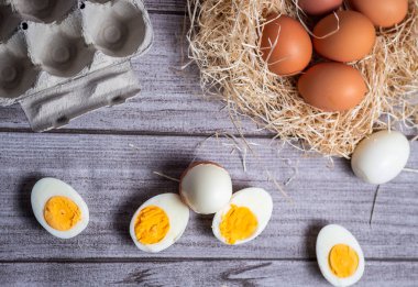 Ön planda doğal yumurtalarla süslenmiş organik haşlanmış yumurtalar ve çiftçi pipetleri ve yumurtaların bırakıldığı tipik kutu.