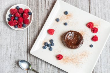 Çikolata renginde, ahududu ve yaban mersini süslemeli gri süslemeli.