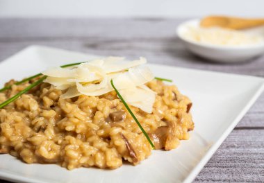 Ön planda parmesan cipsli risotto yan perspektiften çekilmiş.