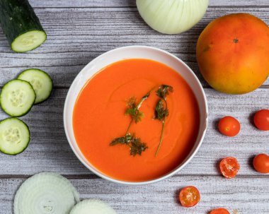 Beyaz bir kasede gazpacho ve zarif ve kırsal gri arka plandaki dekoratif malzemeler.