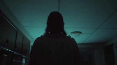 Beyaz elbiseli Asyalı kadın perili evde öne doğru uçuyor.