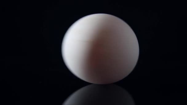 Пряжа белое сырое яйцо на черном фоне — стоковое видео