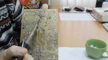 Bir teknisyen bir çip bir havya ile çalışma