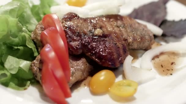 Vepřový steak s cherry rajčaty a bylinkami na bílé plotně — Stock video