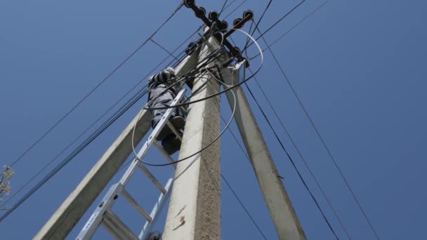 Trabalho de eletricidade, homem reparos poste elétrico vestindo todo o equipamento de segurança — Vídeo de Stock