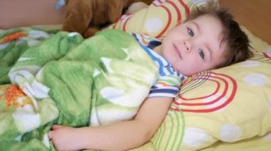 Çocuk uyanıyor ve mutlu bir şekilde gülümsüyor..