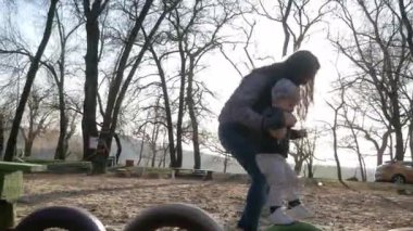 Parktaki mutlu aile. Güneşin altında çocuklar el ele tutuşur.