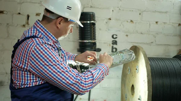 Man plugging in a fiber optic hub cable Royalty Free Stock Images