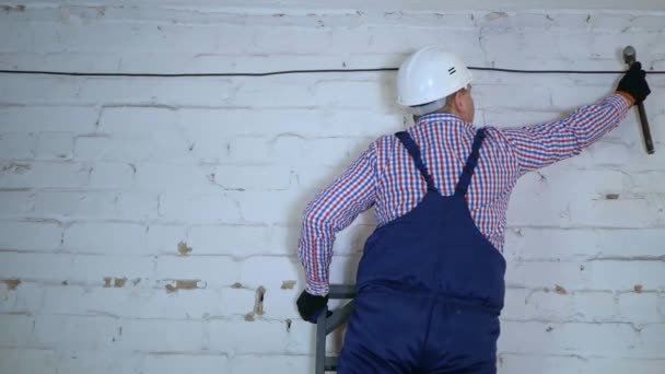 Bau einer Glasfaser-Kommunikationsleitung entlang der Mauer. — Stockvideo