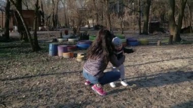Parktaki mutlu aile. Güneşin altında çocuklar el ele tutuşur.