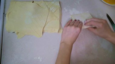 Hamur un serpiştirilmiş, merdaneyle yuvarlanmış, yumuşak odaklı, hafif ışıklı, ağır çekimde.