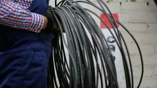 Engineer werkt naast signaal bolder tegen witte muur met glasvezel connector — Stockvideo