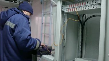Optik yama kablosuyla sunucu odasında ağ mühendisi.