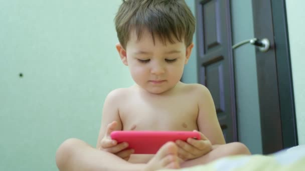 Adorable niño pequeño hijo usando smartphone viendo videos divertidos — Vídeos de Stock