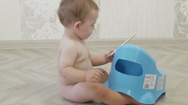 Baby sitter på en gryta tittar in i telefonen — Stockvideo