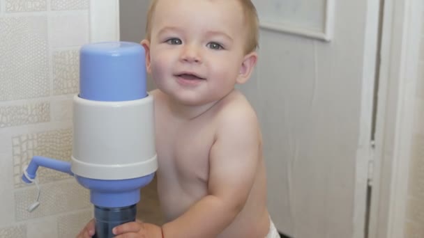 Engraçado menino fica com um refrigerador de água — Vídeo de Stock